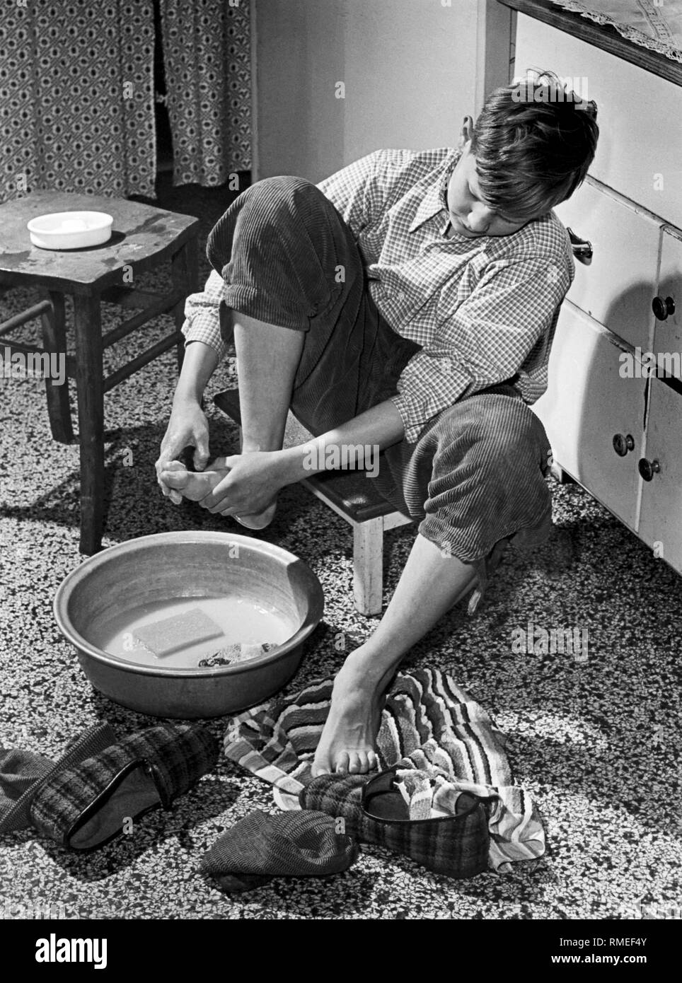 Teenager washes his feet, 50s Stock Photo