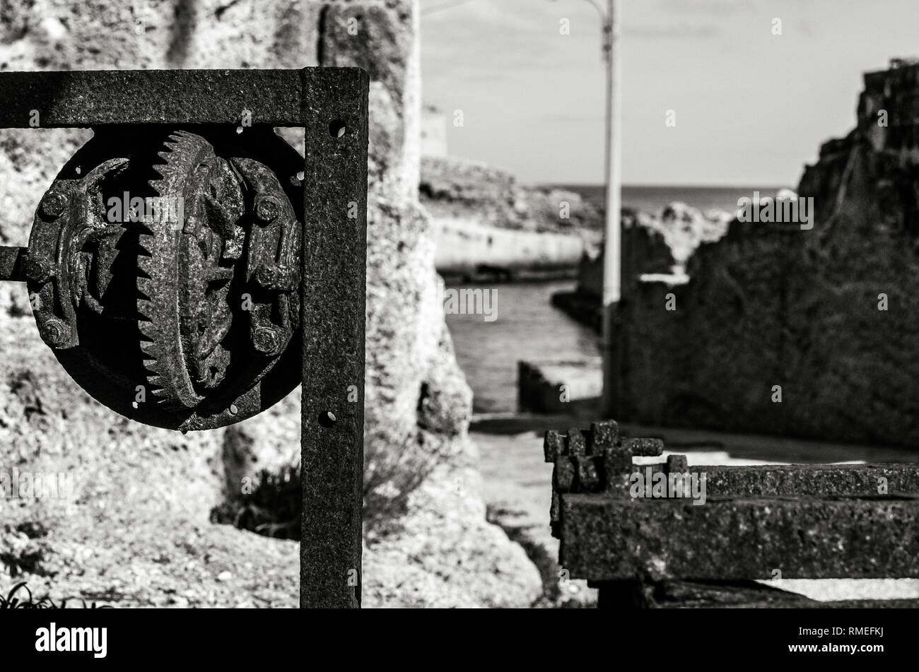 detail of an old rusty device along the sea in bw Stock Photo