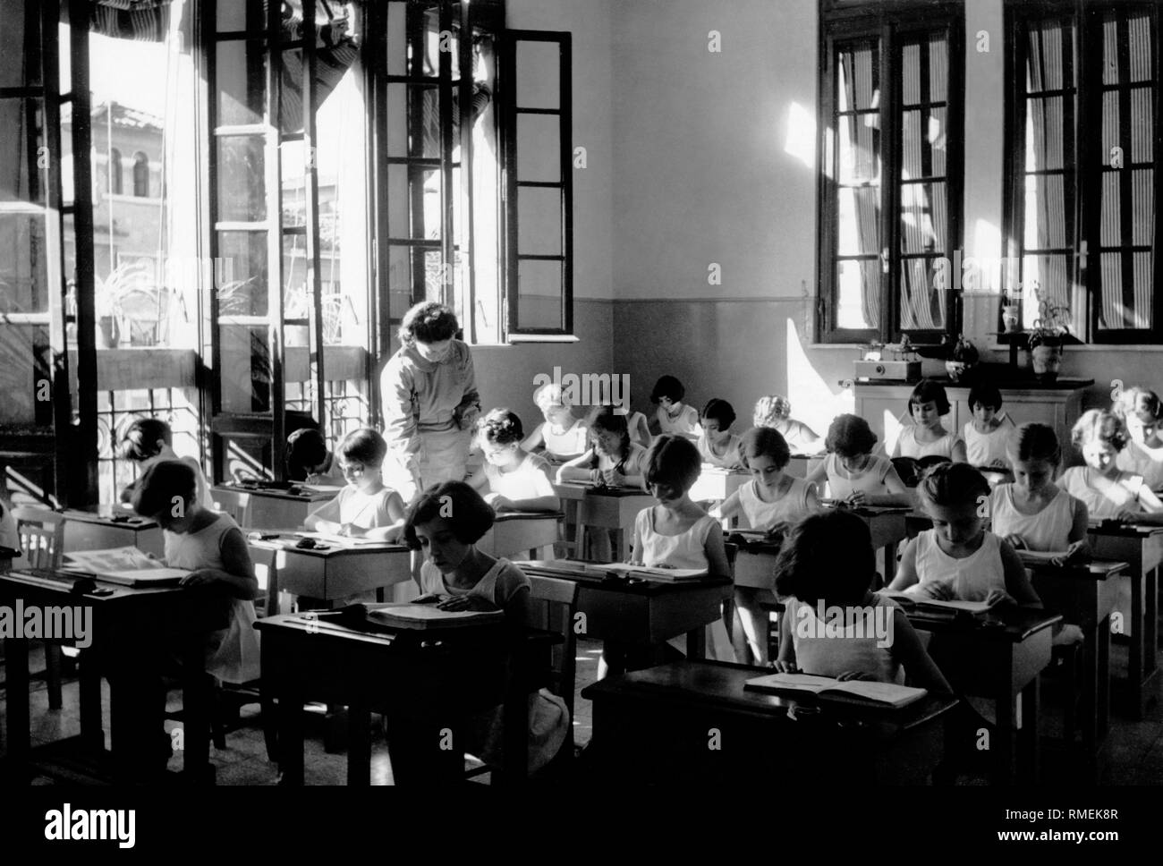 italy, rome, summer camp, little girl reading in classroom, 1930 Stock Photo