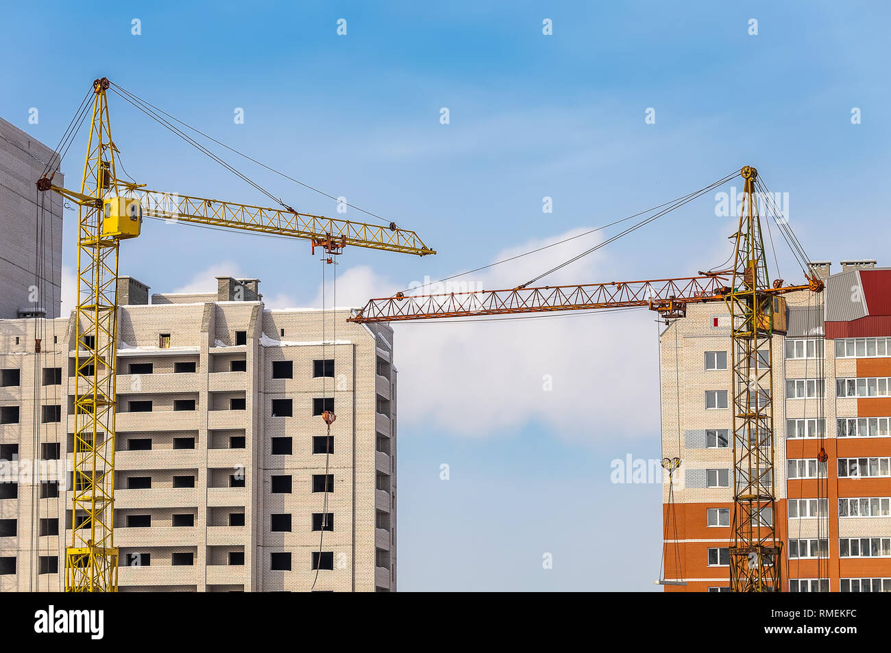 View of Construction Site with Two Apartment Buildings and Cranes. Blue ...