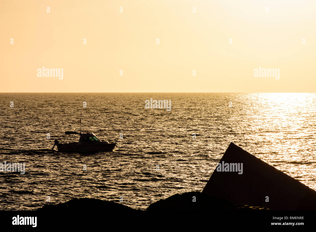 Boat silhouette against sea during sunset Stock Photo - Alamy