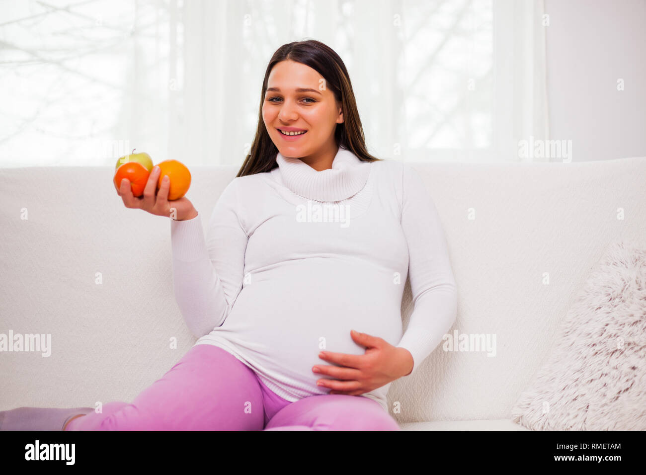 Pregnant woman is holding fresh fruit. Healthy eating. Stock Photo