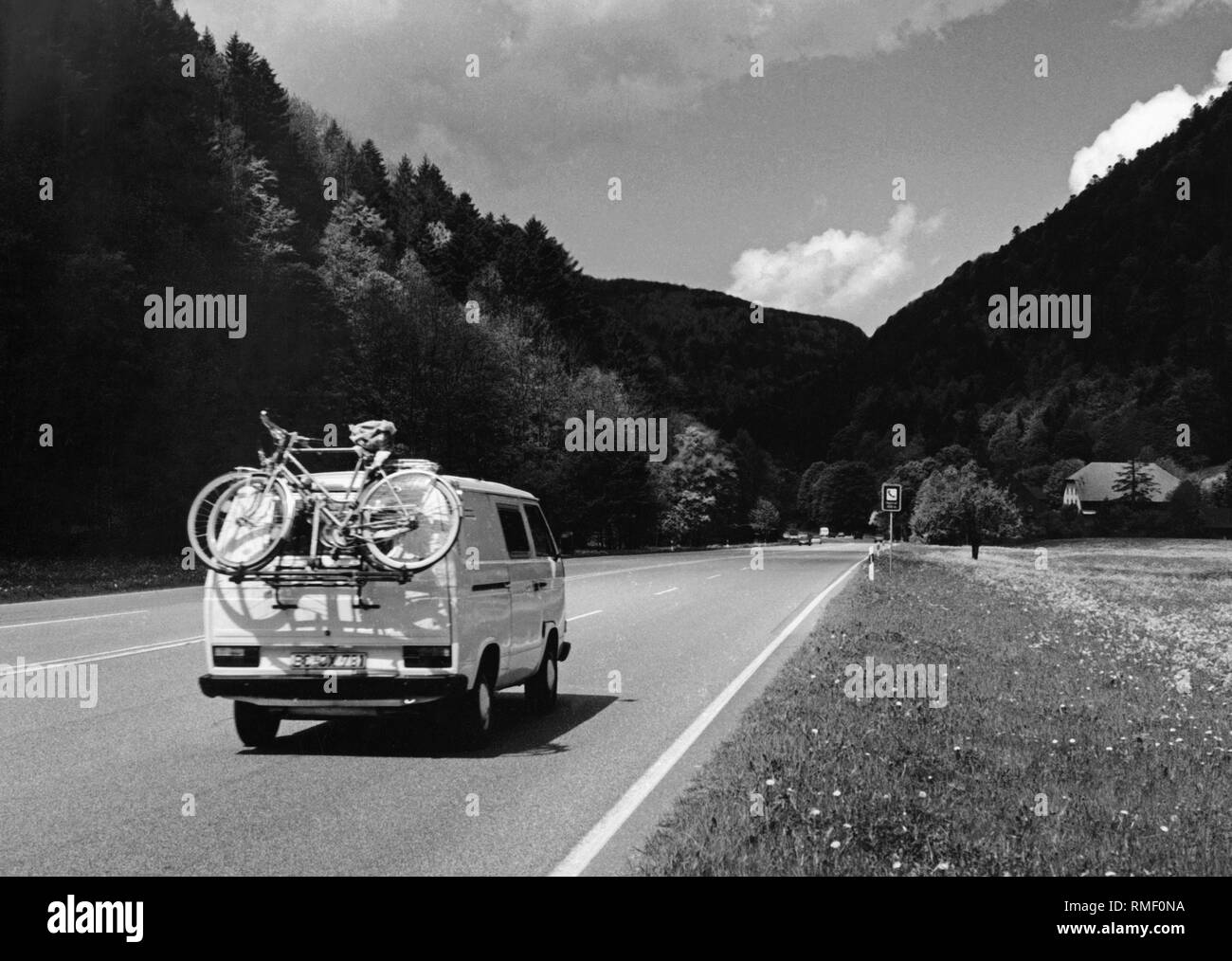 A VW T3 bus with bike rack on a country road. Stock Photo