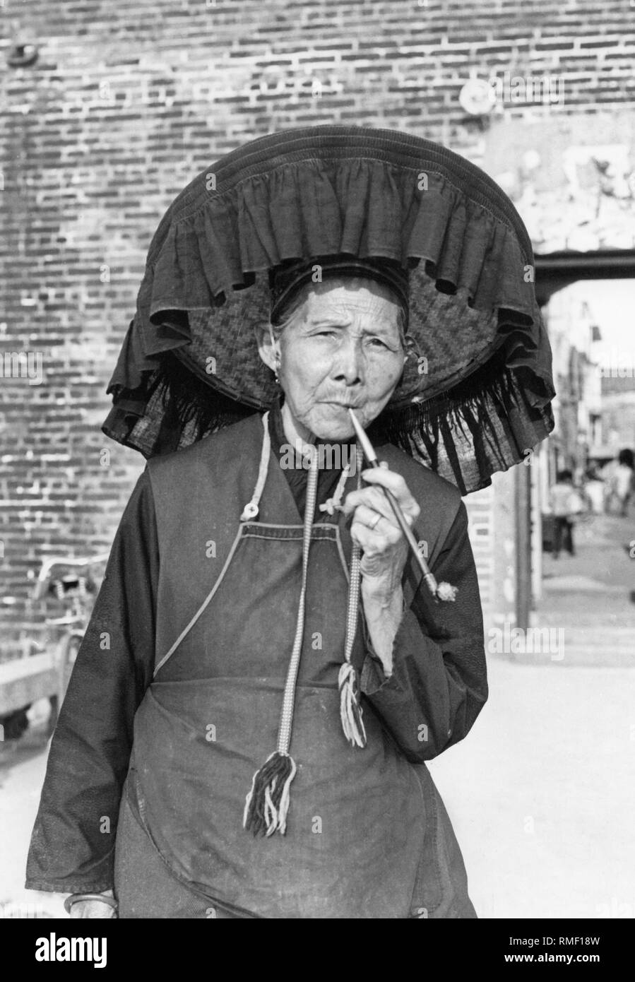 An old woman outside a city gate in the so-called 'New Territories', the northern part of Hong Kong. Stock Photo