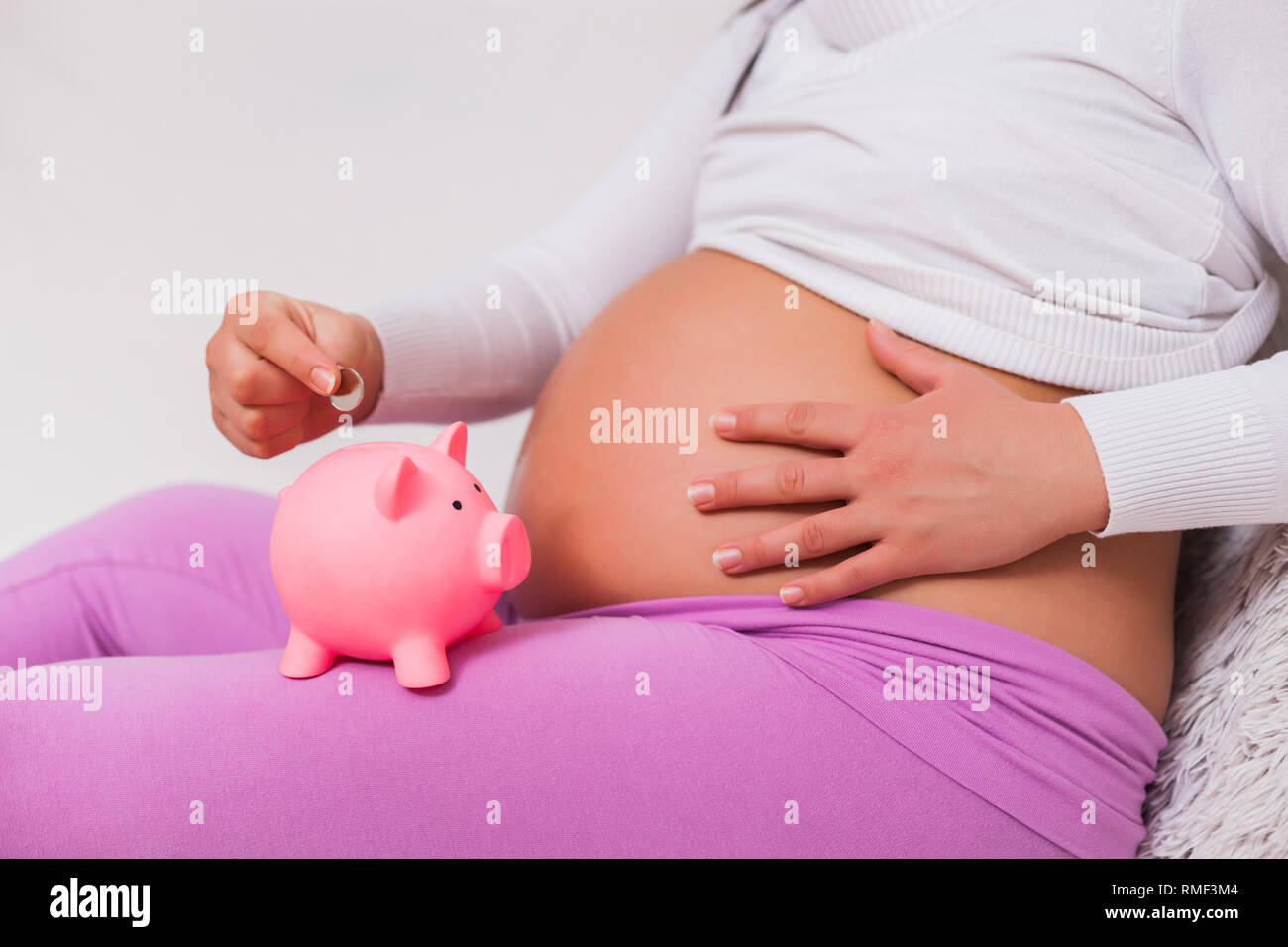 Pregnant woman saving money for her child. Stock Photo