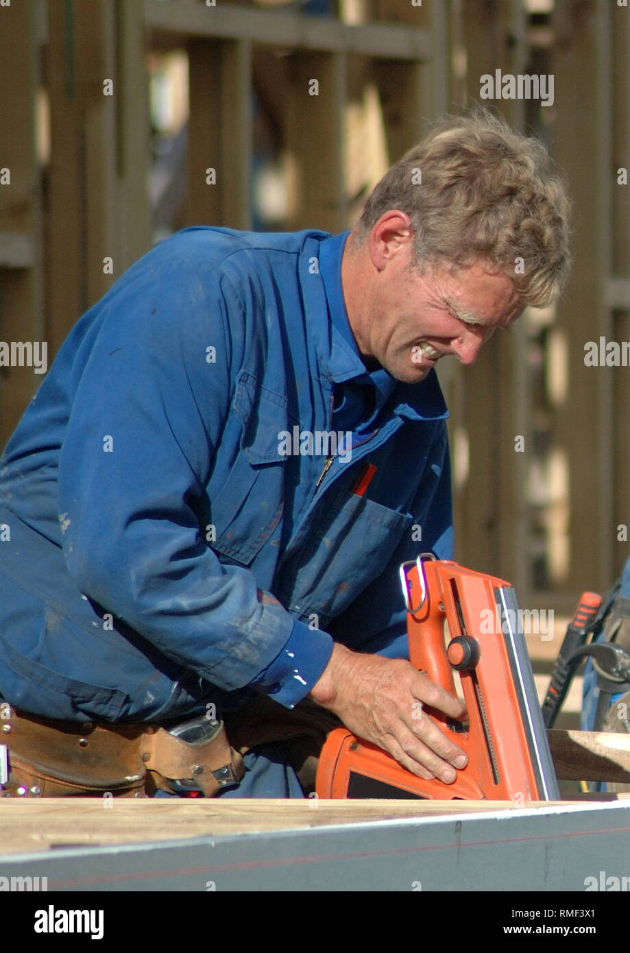 builder using nail gun on building site Stock Photo Alamy