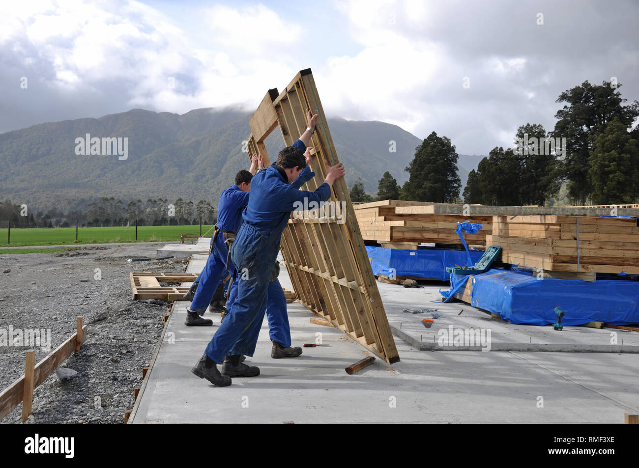 Builders stand up a wall framing section on a large building Stock
