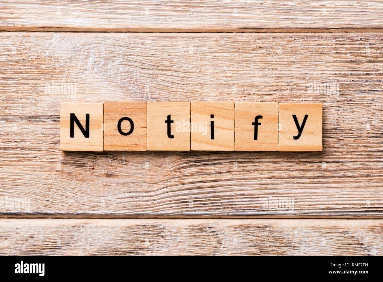NOTIFY word written on wood block. NOTIFY text on wooden table for your