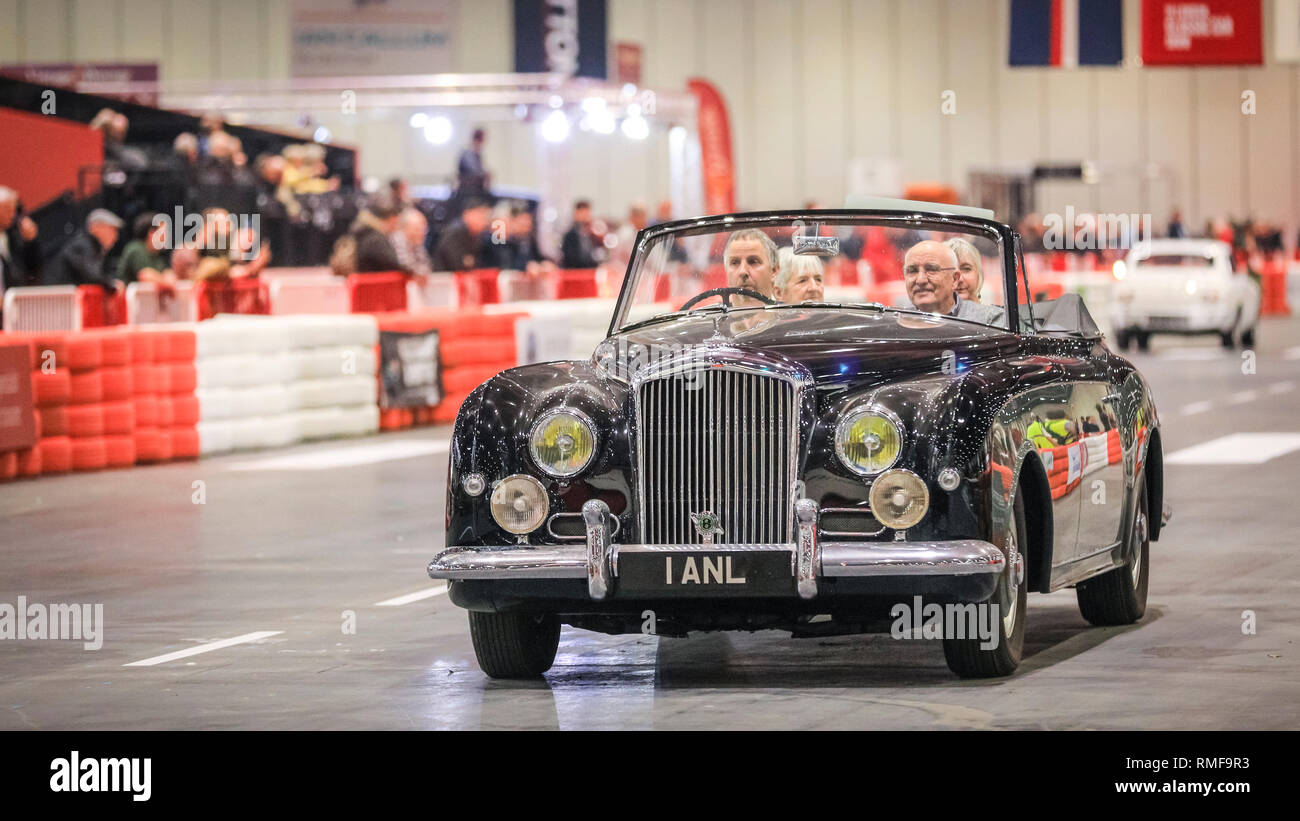 ExCel, London, UK, 14th Feb 2019. A vintage car races down the Grand Avenue track ,The London Classic Car Show 2019 opens at ExCel Exhibition Centre in London Docklands. The show  brings together classic car owners, collectors, experts and enthusiast with dealers, manufacturers and car clubs in a celebration of motoring and classic cars. Credit: Imageplotter News and Sports/Alamy Live News Stock Photo