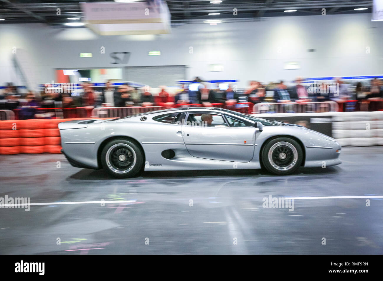 ExCel, London, UK, 14th Feb 2019. A sporty Jaguar XJ220 races down the Grand Avenue track ,The London Classic Car Show 2019 opens at ExCel Exhibition Centre in London Docklands. The show  brings together classic car owners, collectors, experts and enthusiast with dealers, manufacturers and car clubs in a celebration of motoring and classic cars. Credit: Imageplotter News and Sports/Alamy Live News Stock Photo