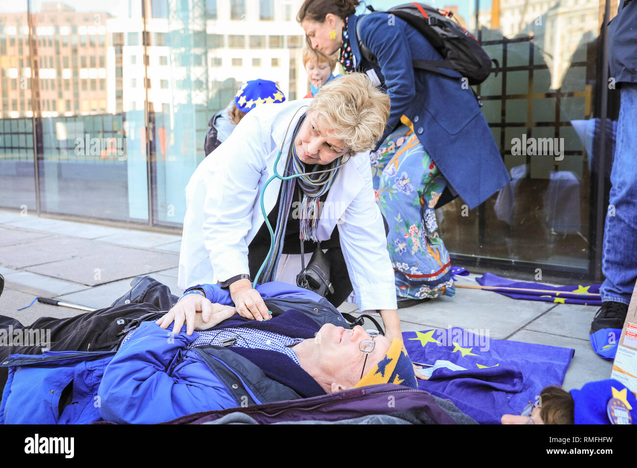 Department of Health, London, UK, 15th Feb 2019. Anti Brexit protesters lie down in death cloths, body bags and with their life saving medicines in front of the Department of Health. The group have organised a 'Death By Brexit' outside the Department of Health and Social Care in Westminster, London. The protest aims to highlight the risk of medical supplies in case of a no deal Brexit, and potential dangers to the health and lifes of those who depend on medicines imported from Europe. Credit: Imageplotter News and Sports/Alamy Live News Stock Photo