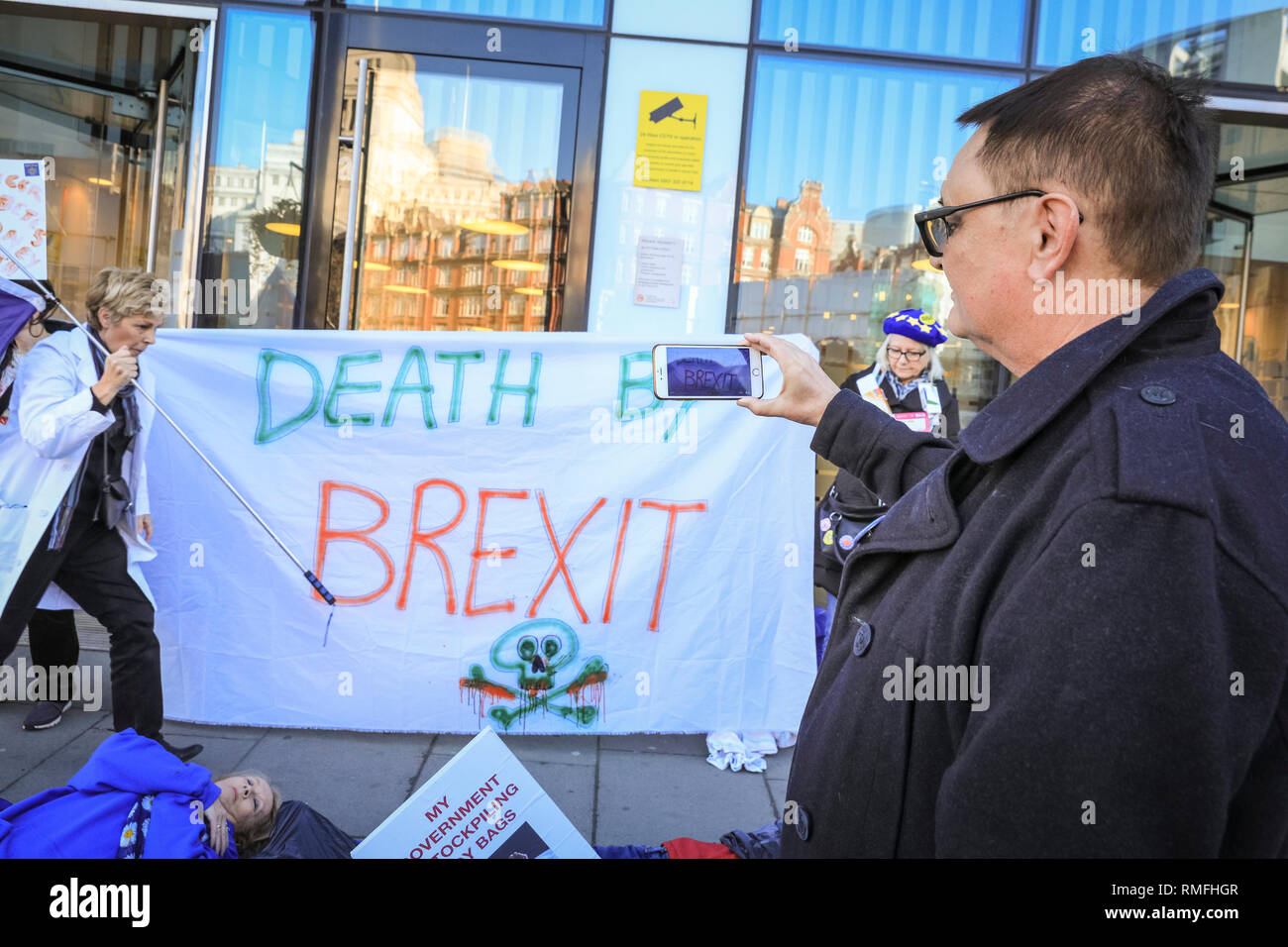 Department of Health, London, UK, 15th Feb 2019. Anti Brexit protesters lie down in death cloths, body bags and with their life saving medicines in front of the Department of Health. The group have organised a 'Death By Brexit' outside the Department of Health and Social Care in Westminster, London. The protest aims to highlight the risk of medical supplies in case of a no deal Brexit, and potential dangers to the health and lifes of those who depend on medicines imported from Europe. Credit: Imageplotter News and Sports/Alamy Live News Stock Photo