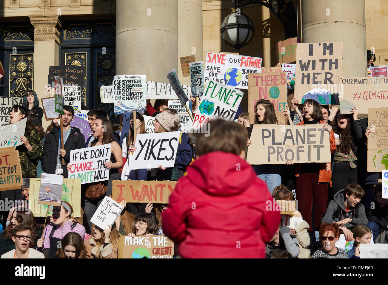 Leeds, UK. 15th Feb, 2019. Young people protesting outside Leeds City Hall during a national climate change strike day of action watched on by a young infant. Credit: Kevin J. Frost/Alamy Live News Stock Photo