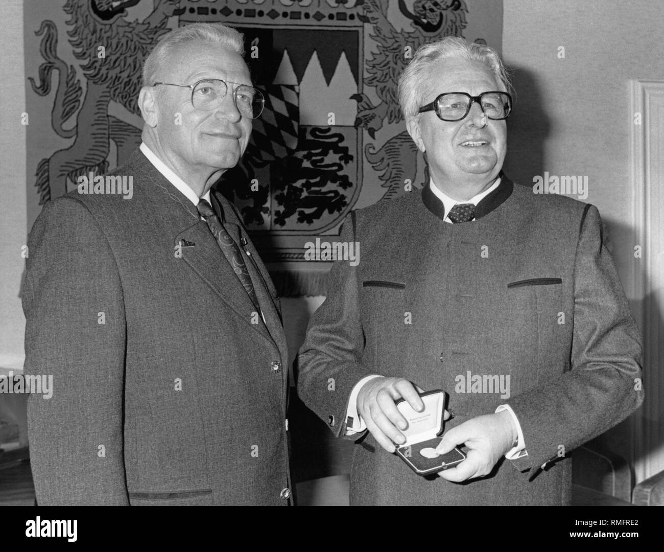 Bavarian Landtag President Franz Heubl (CSU, left) awarded the SPD politician Hans-Jochen Vogel the gold Bayerische Verfassungsmedaille in recognition of his services as mayor of Munich. In the background, the coat of arms of Bavaria (undated photo). Stock Photo