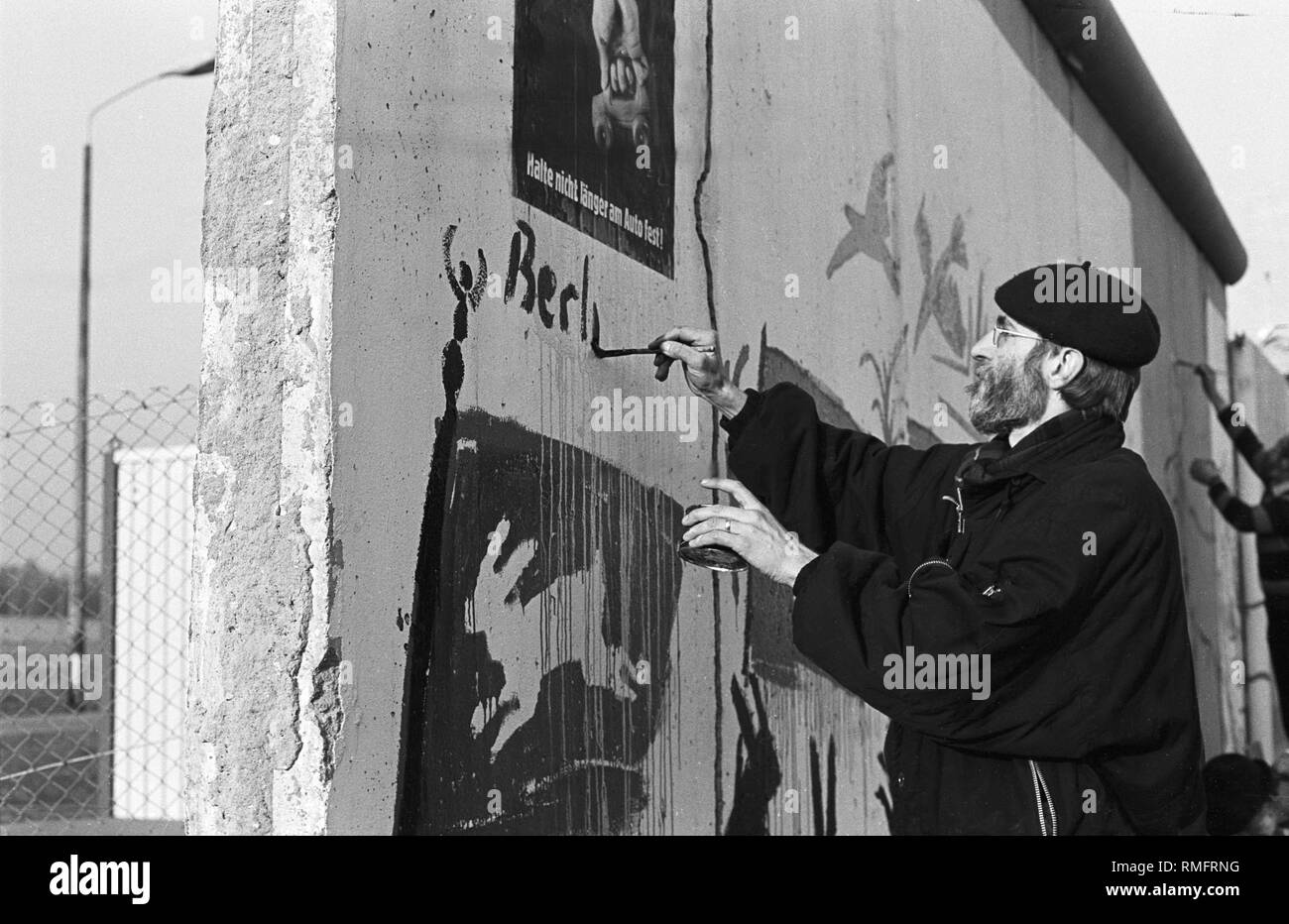 After the demonstration on the 19th of November, graphic artist Manfred Butzmann and other artists paint his hare motif on the Wall on Potsdamer Platz(later removed by border guards), Germany, Berlin-Mitte, 19.11.1989. Stock Photo