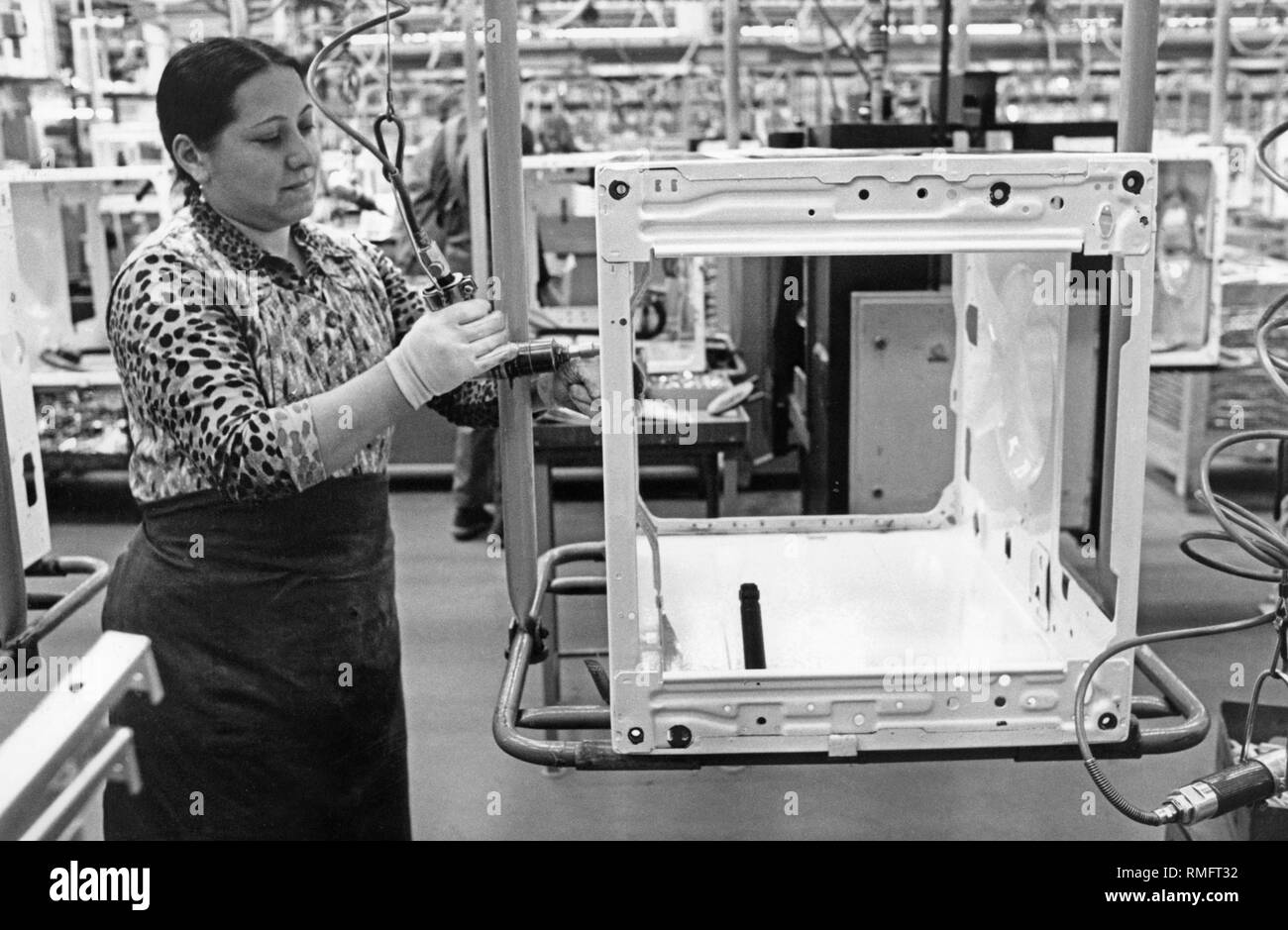 A woman with a migration background works in the washing machine assembly of the company Miele in Guetersloh. Stock Photo