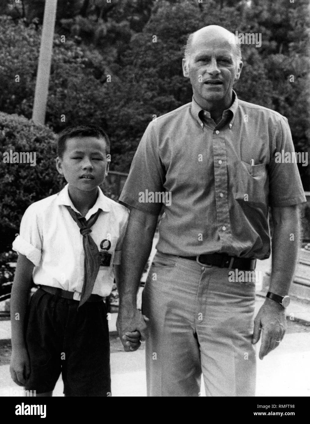 The chief correspondent of the Sueddeutsche Zeitung, Hans Ulrich Kempski, is led by a 'little red soldier' through the facilities of the Youth Palace in Shanghai. He holds the boy by the hand. Stock Photo