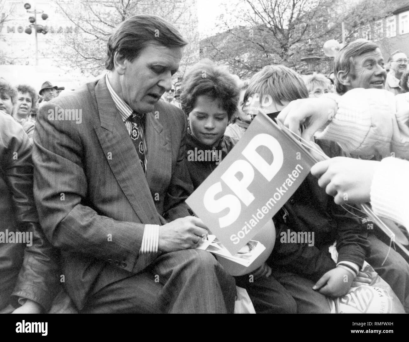 The SPD top candidate in the state election in Lower Saxony, Gerhard Schroeder, gives a boy an autograph. Stock Photo