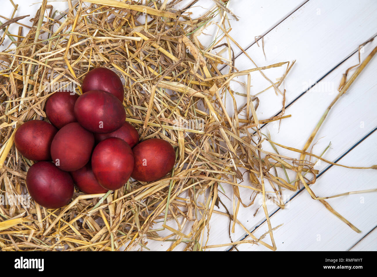 Red Easter eggs in a straw nest Stock Photo - Alamy