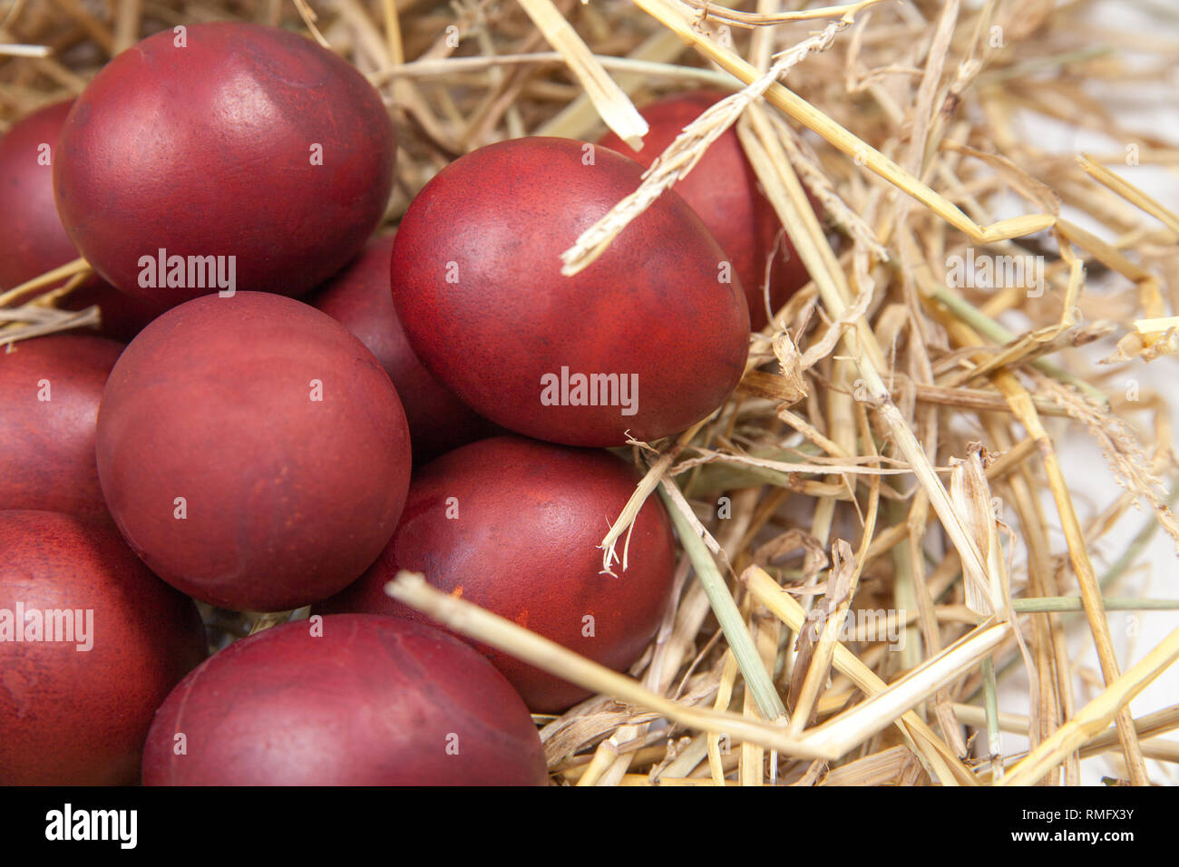 Red Easter eggs in a straw nest Stock Photo - Alamy