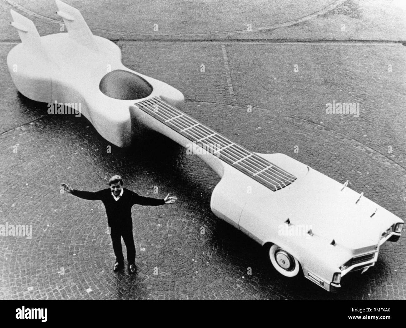 American designer Jay Ohrberg next to his guitar-shaped car, which he built  on the basis of a Cadillac as a "mobile monument" in honor of Elvis  Presley. The vehicle is 12.19 meters