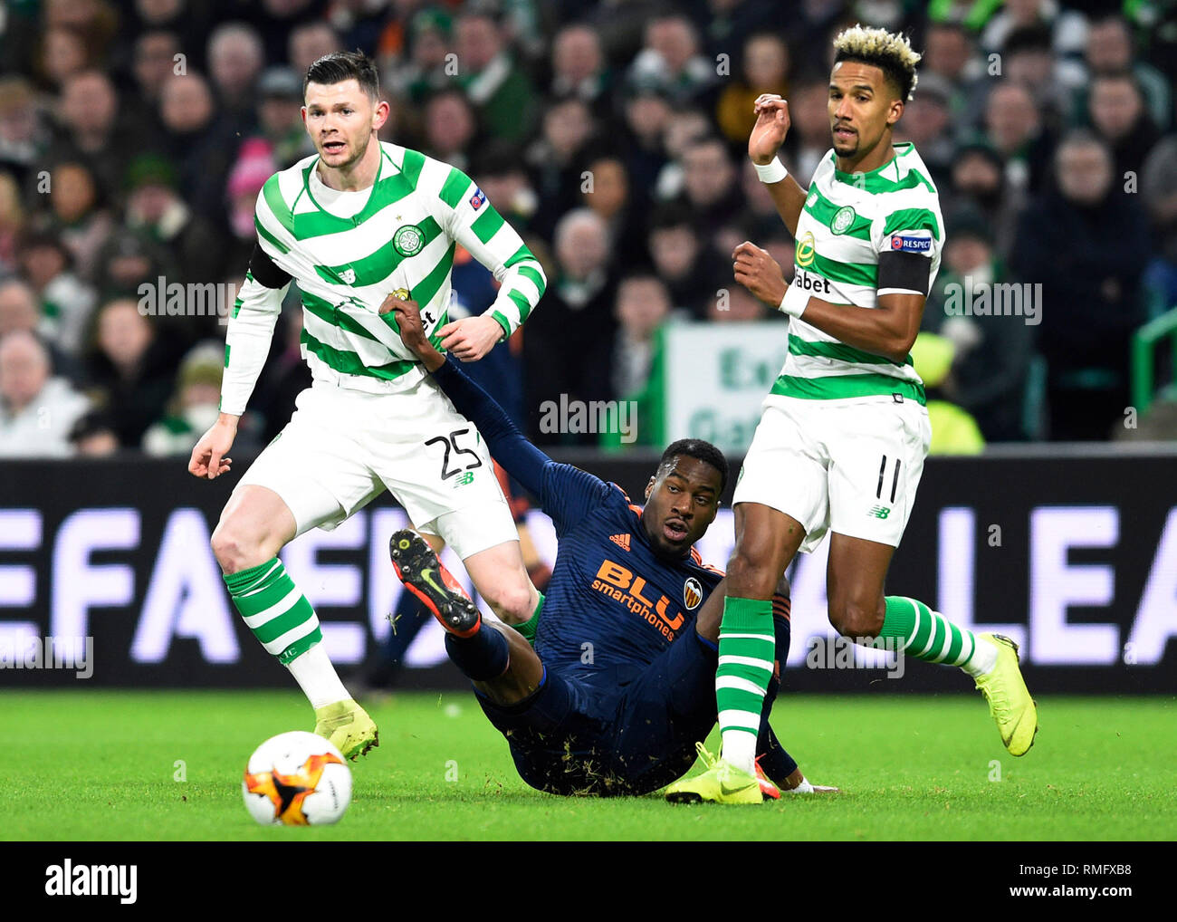 Celtic's Oliver Burke (left) and Scott Sinclair (right) battle for the ball with Valencia's Geoffrey Kondogbia (centre) during the UEFA Europa League round of 32, first leg match at Celtic Park, Glasgow. Stock Photo