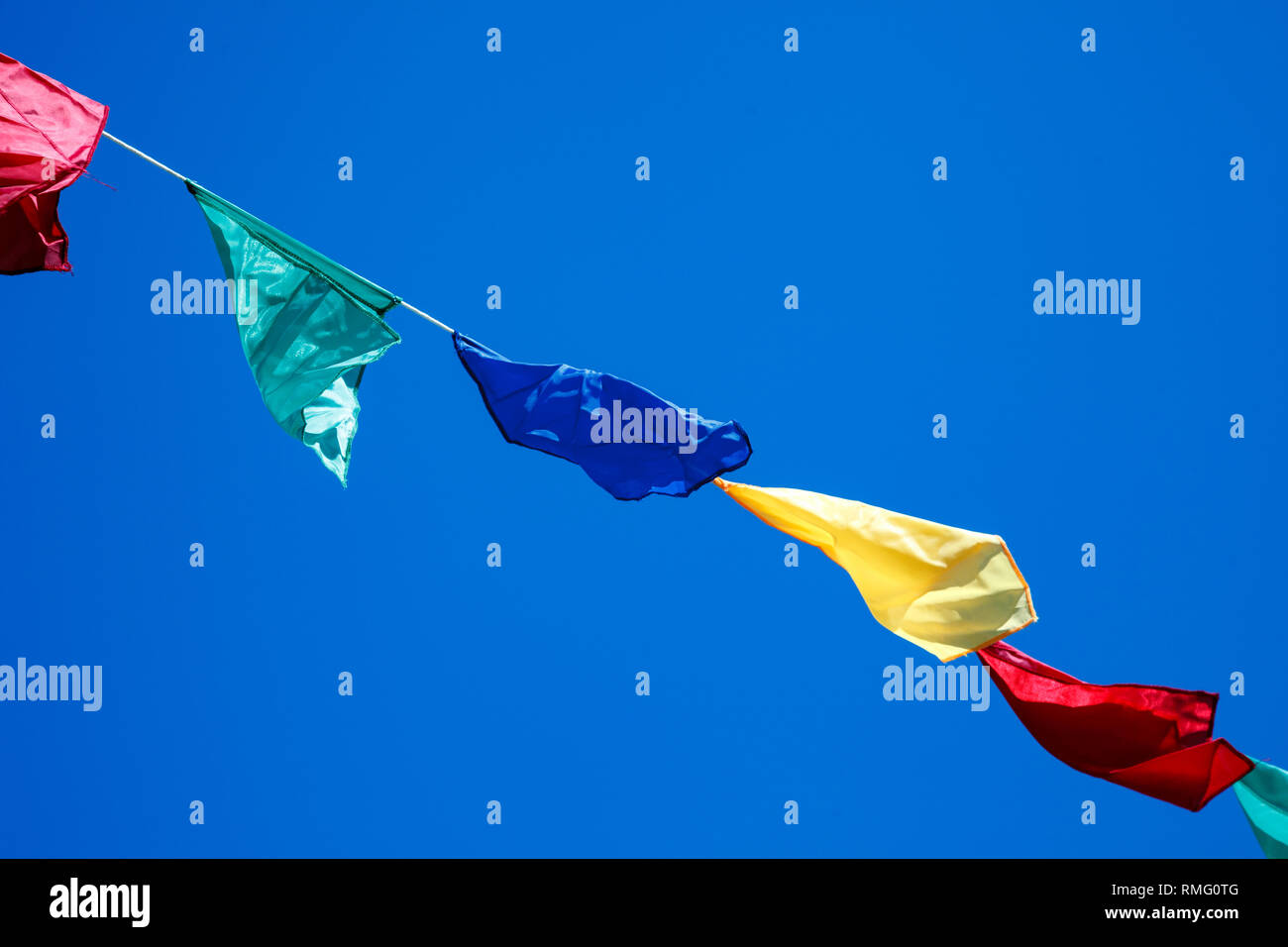colorful bunting flags against a blue saturated sky Stock Photo - Alamy