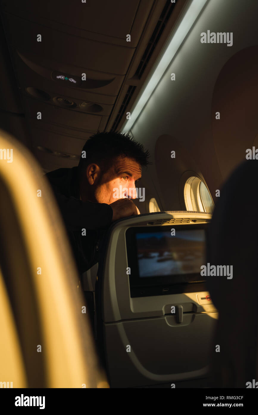 Thoughtful man looking out plane window