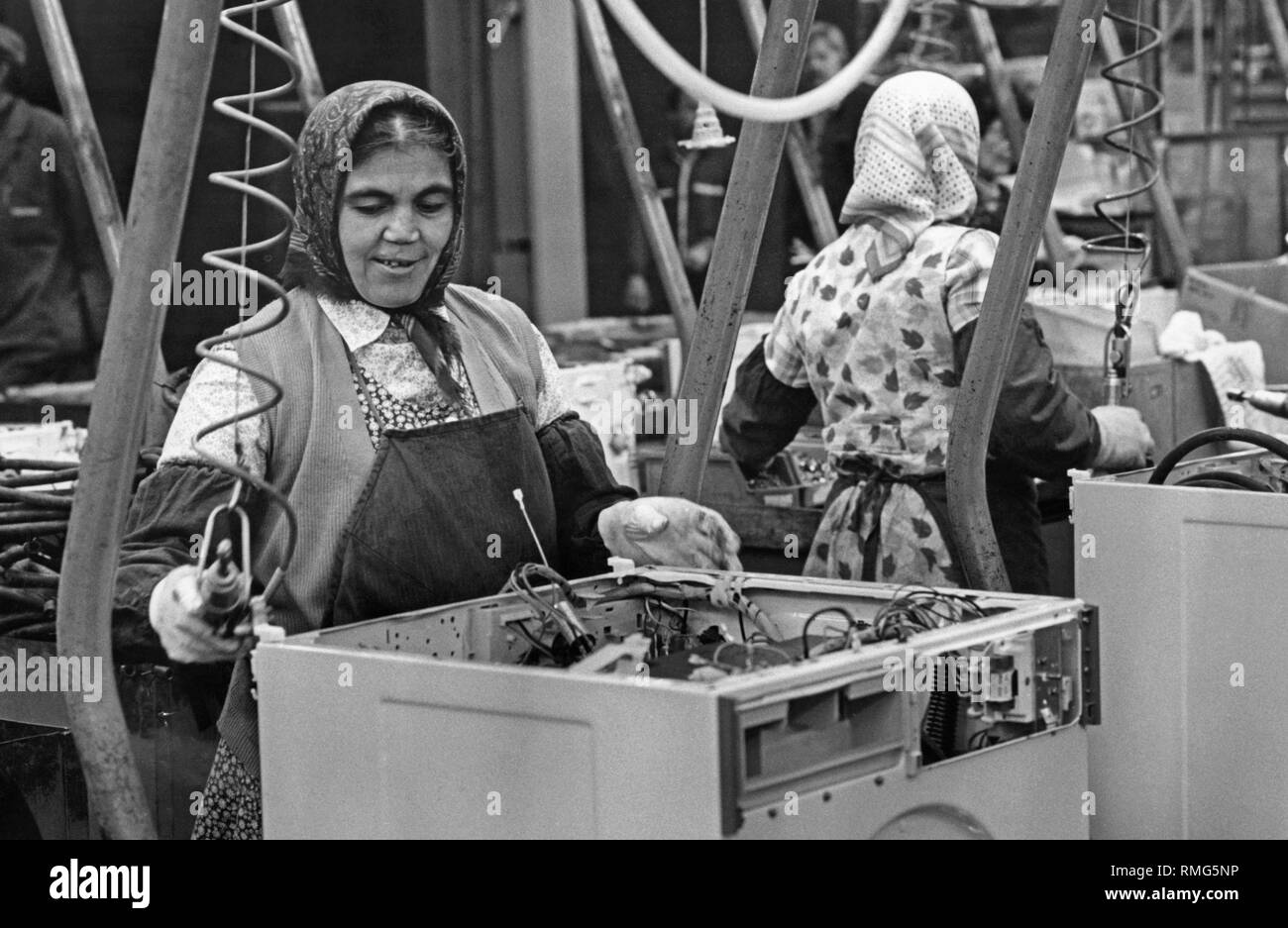 Two migrants with Turkish roots at their workplace on the assembly line of the company Miele. Stock Photo