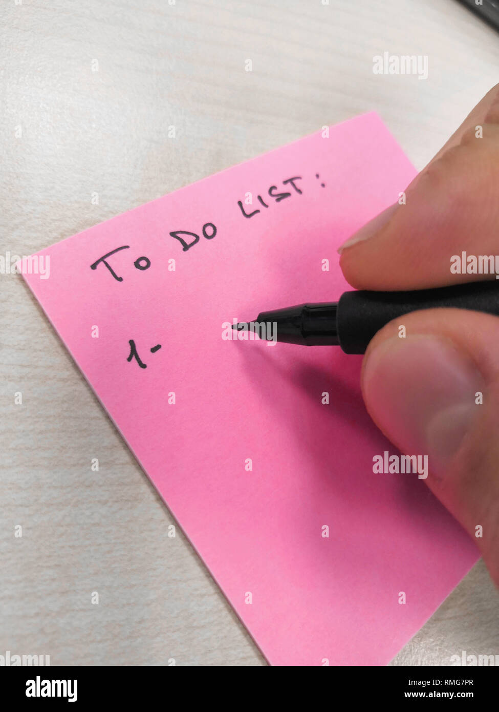 hand writing with pen on a sheet of paper post-it Stock Photo