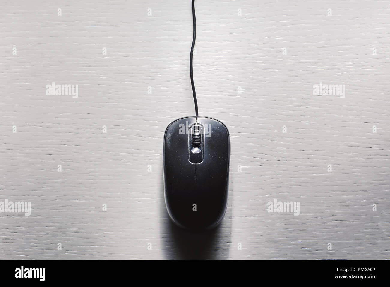 Old dusty black computer mouse on white table Stock Photo - Alamy