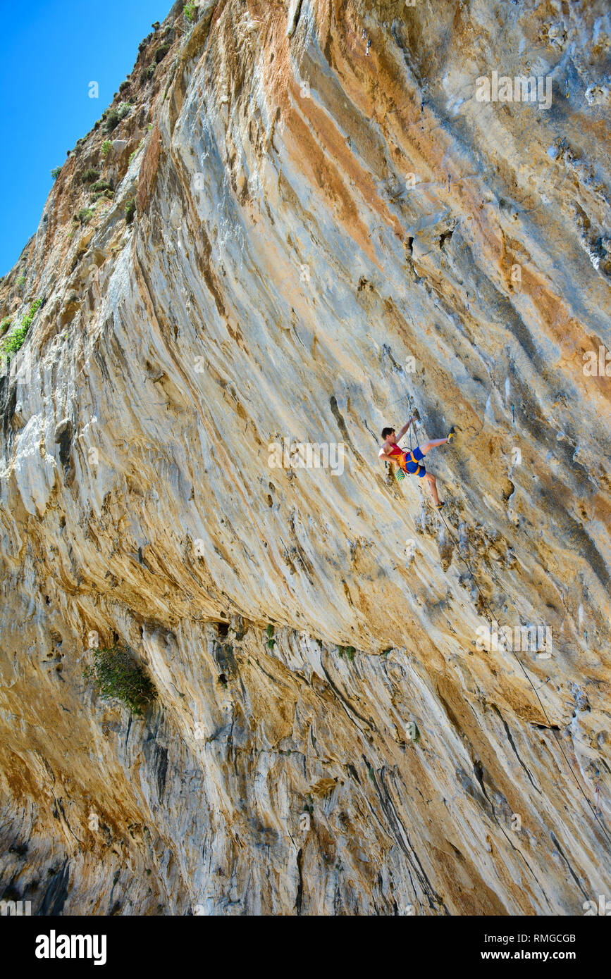 Rock climbing, man on a challenging cliff, lead climbing. Outdoor