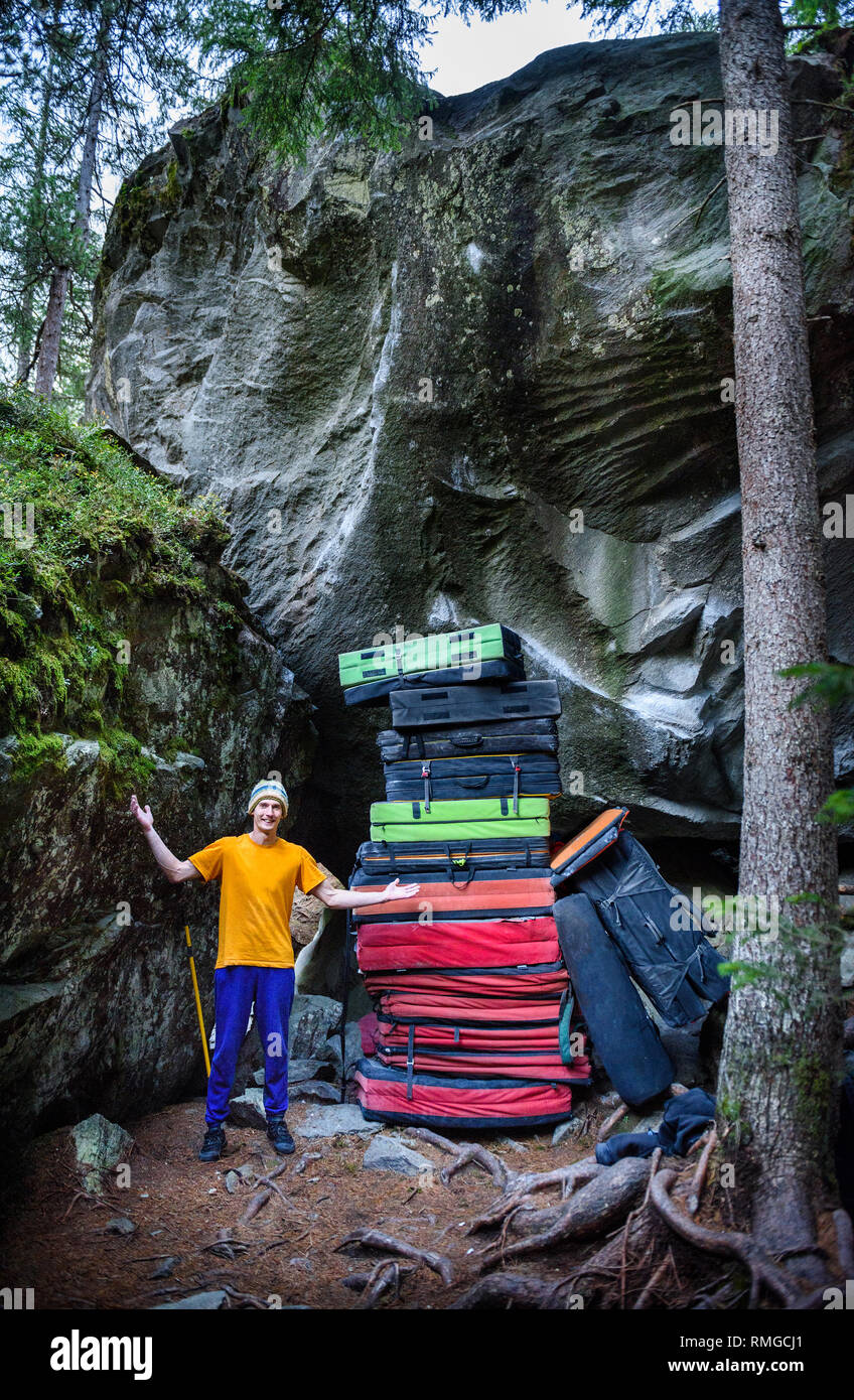 Rock climber demonstraiting a huge pile of crash pads or bouldering mat  used for protection when climbing Stock Photo - Alamy