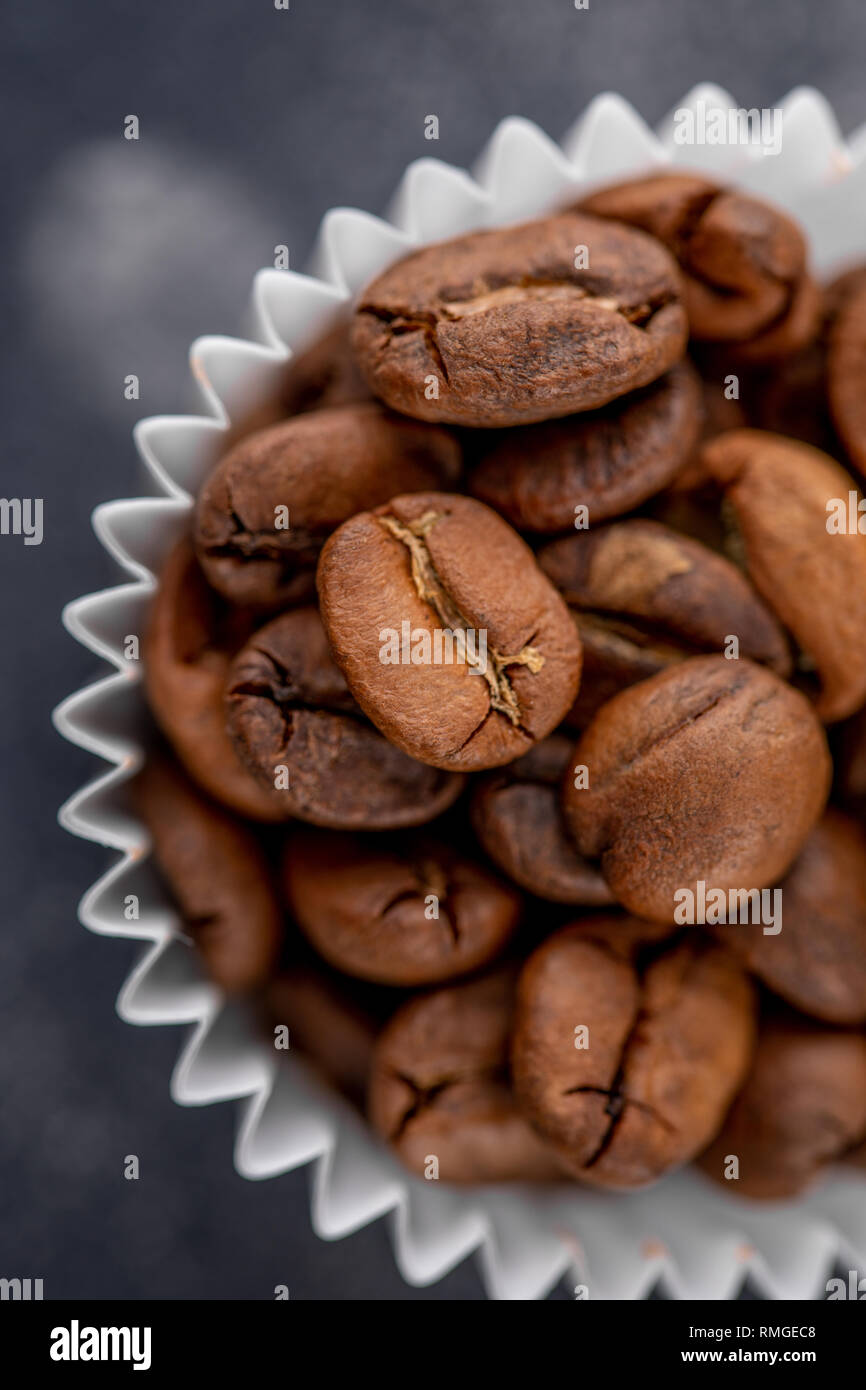Coffee beans in the package from candy on a dark background. Close-up. Stock Photo