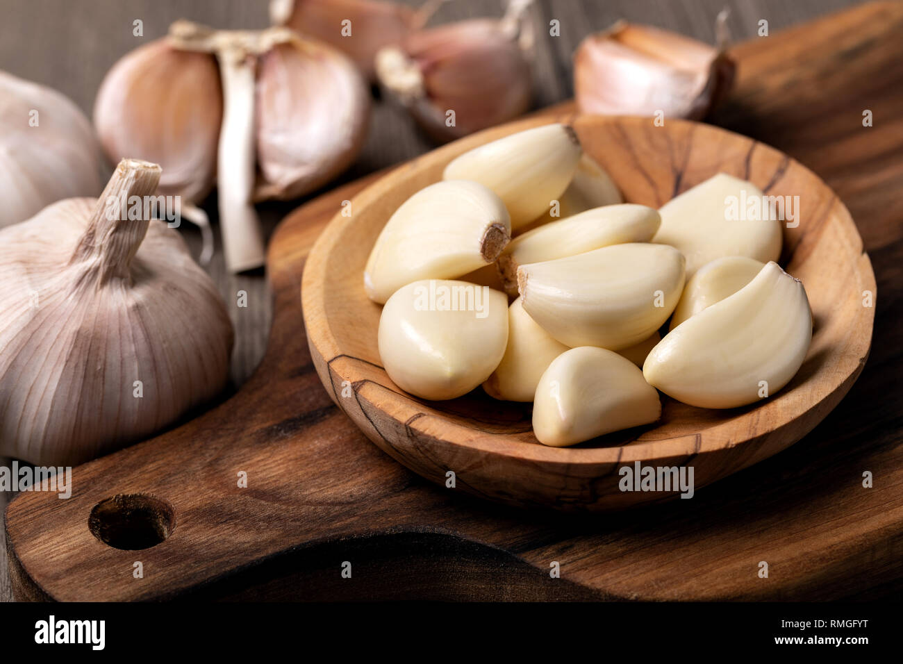 Garlic Cloves and Bulb in vintage wooden bowl Stock Photo - Alamy
