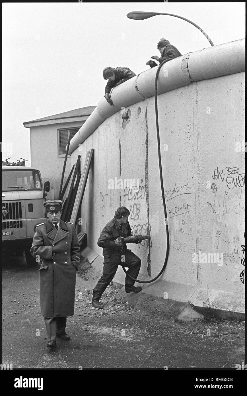 Already in December 1989, GDR border guards begin demolishing the Berlin Wall in some areas of the city. Here, the demolition work at the border crossing Heinrich Heine Strasse in Kreuzberg. Stock Photo