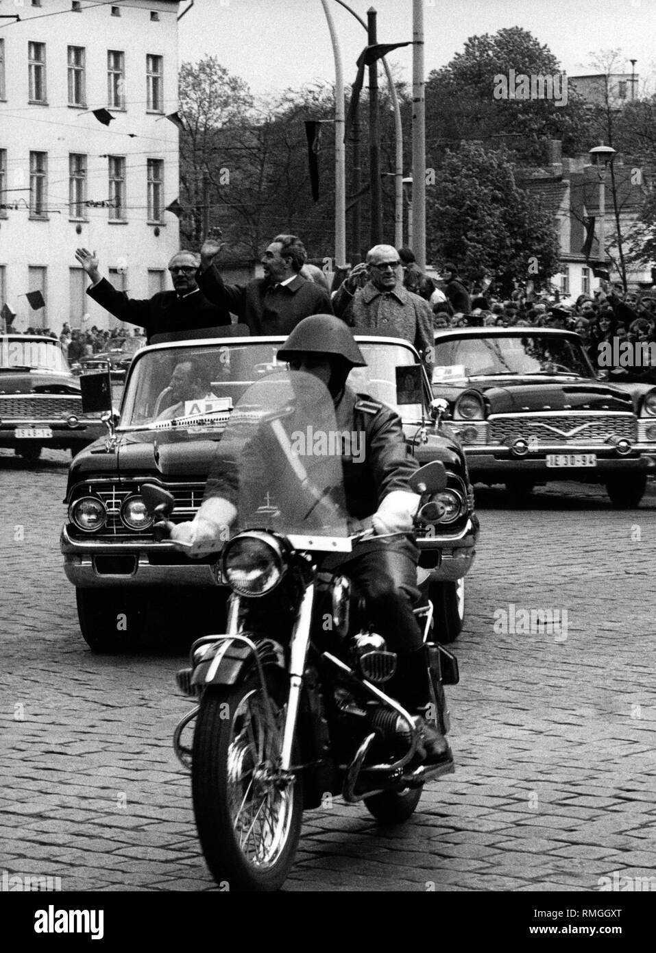 Erich Honecker, Leonid Breshnew and Willly Stroph (from left) in a Chaika Gaz-13 on the way to the guest house Niederschoenhausen Castle, district Pankow East Berlin, in the foreground, an NVA motorcycle. Stock Photo