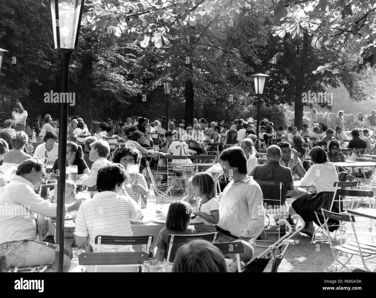 Guests are drinking beer in the beer garden Aumeister in the Englischer Garten in Munich. Stock Photo