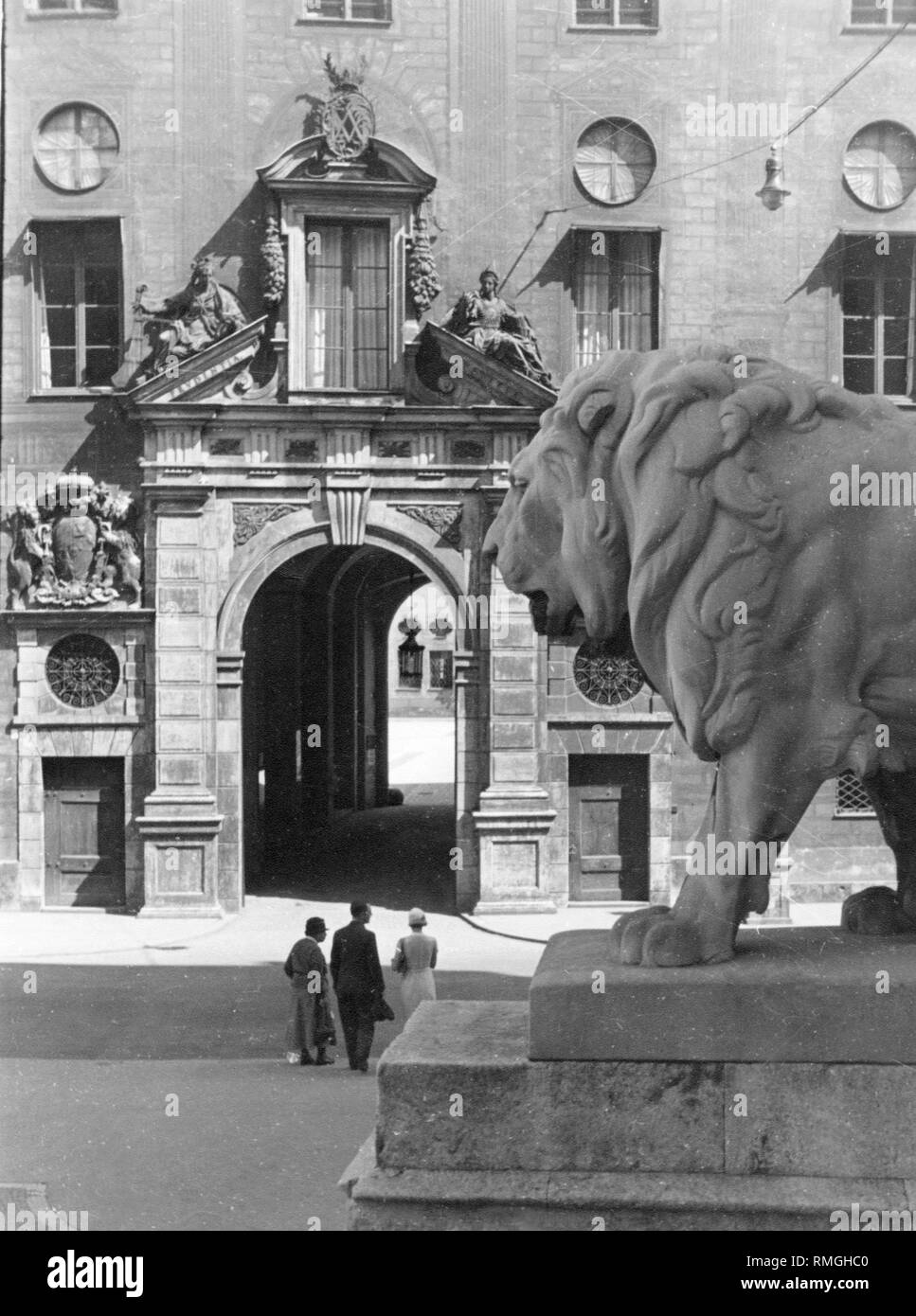 View on a gate of the Munich Residenz. In the foreground stands a Prussian lion with an open mouth. Undated picture. Stock Photo