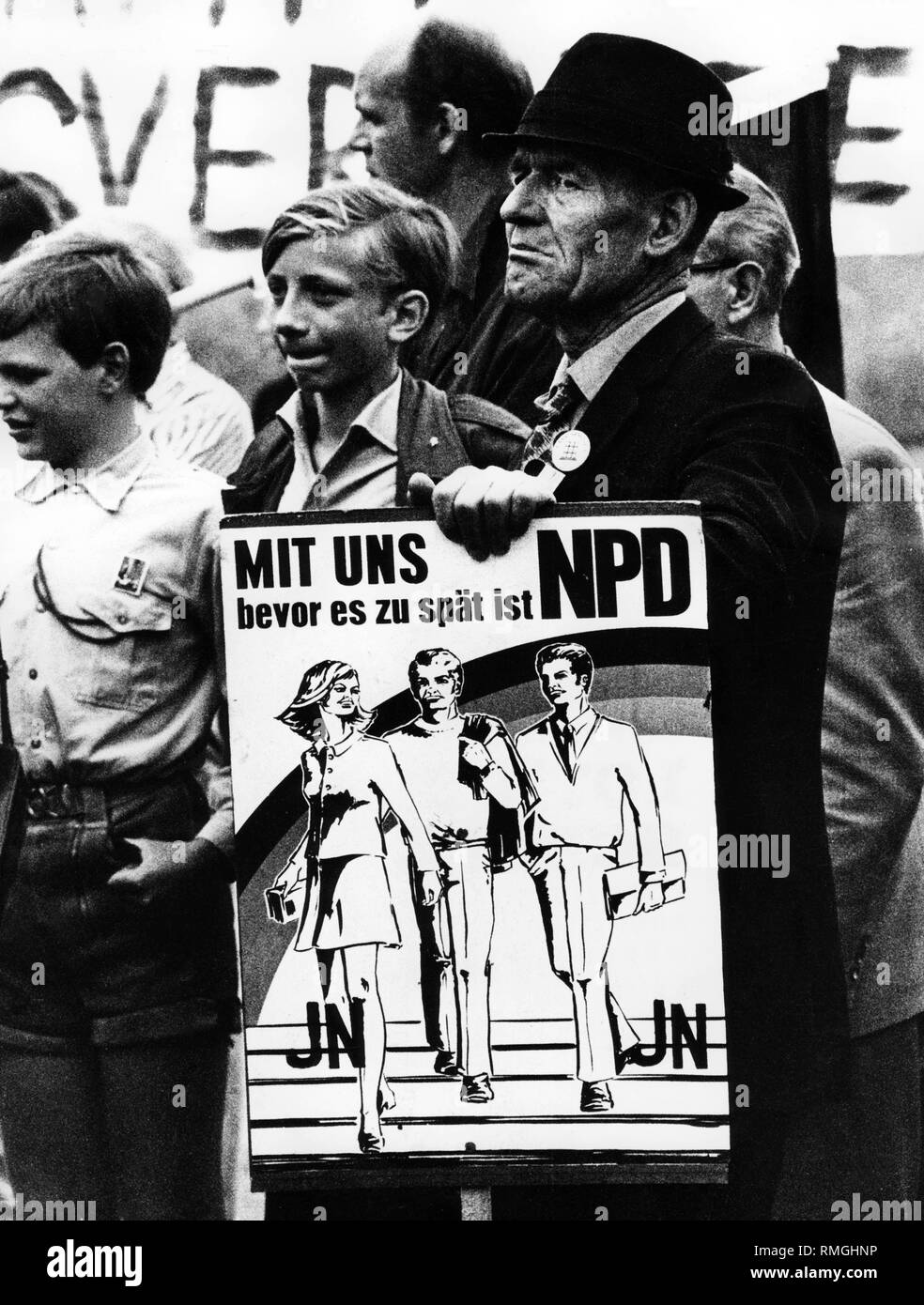 This photo shows an NPD rally in Munich. A participant has a poster reading: 'With us before it's too late NPD'. Stock Photo