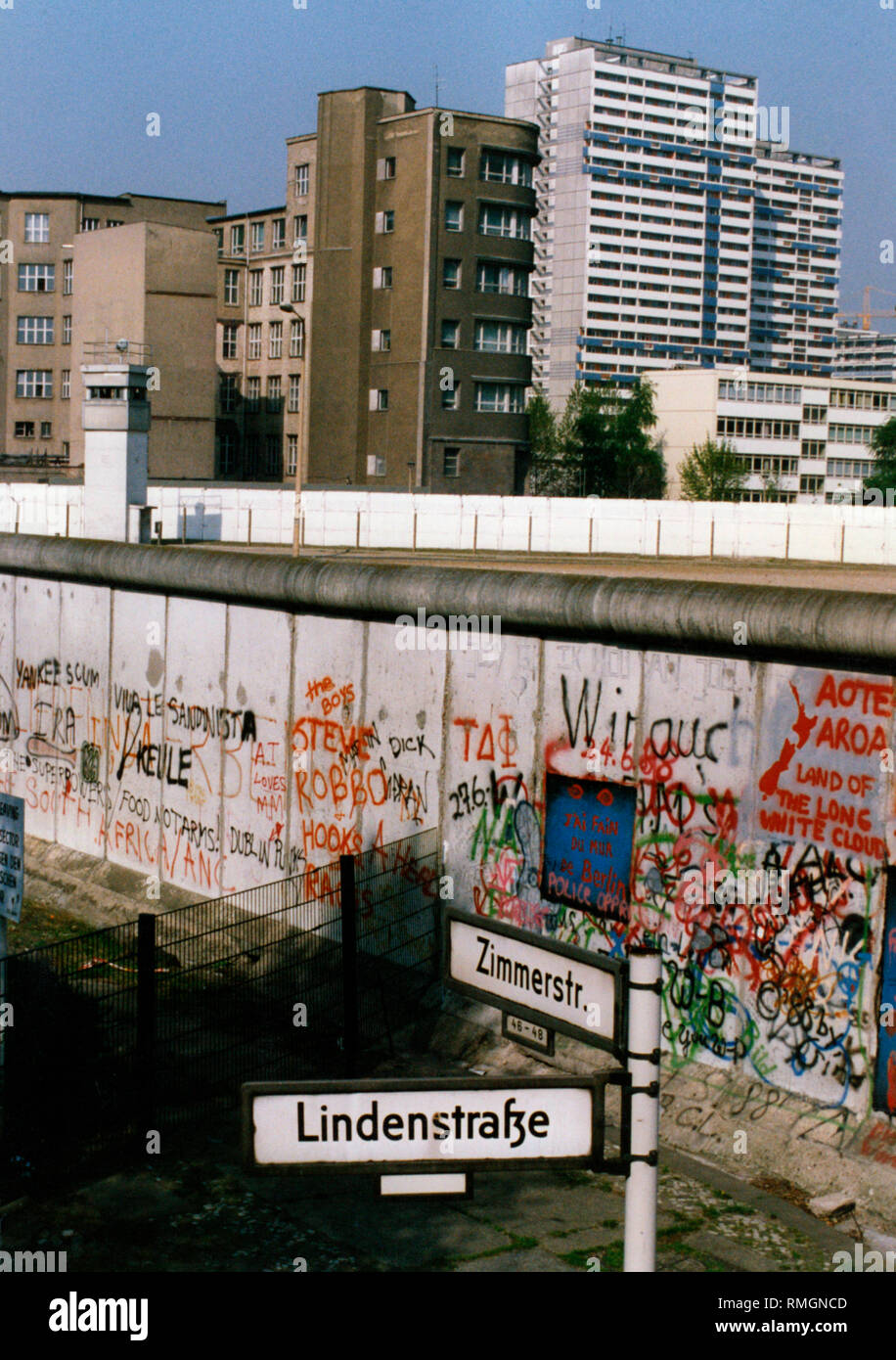 View from the intersection Zimmerstrasse / Lindenstrasse in West Berlin over the Wall with graffti and death stripes on high rise buildings in East Berlin. Stock Photo