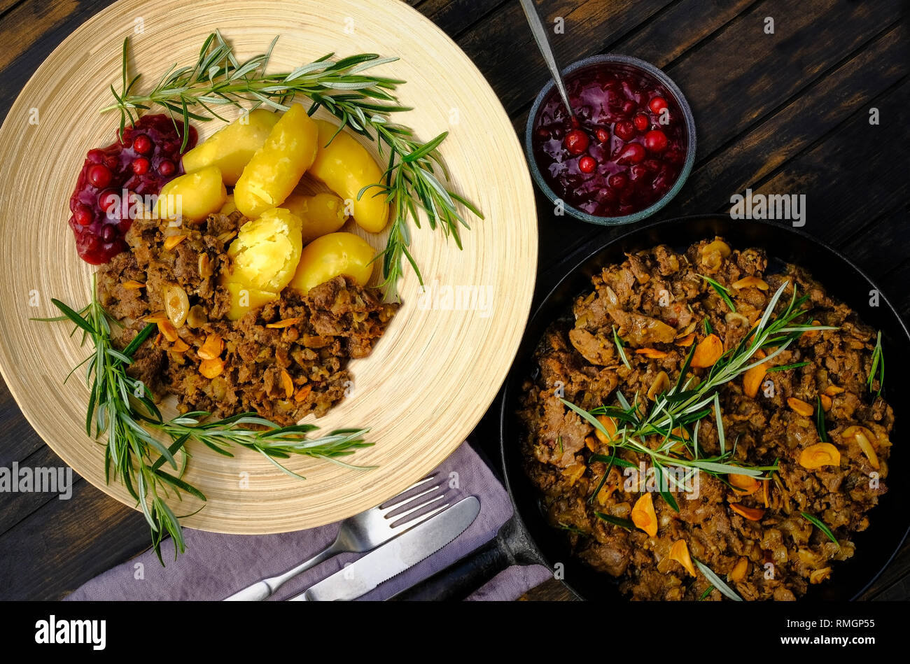 Sauteed reindeer, lingonberry jam and almond potatoes which is a Finnish speciality called also yellow Finn and Puikula. Stock Photo