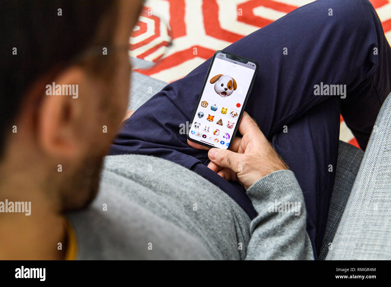 LONDON, UK - SEP 21, 2018: Man using the new astonished dog pet AR Memoji emoji face  on Apple iPhone Xs with the immense OLED retina display and a12 bionic chip, with the face  Stock Photo