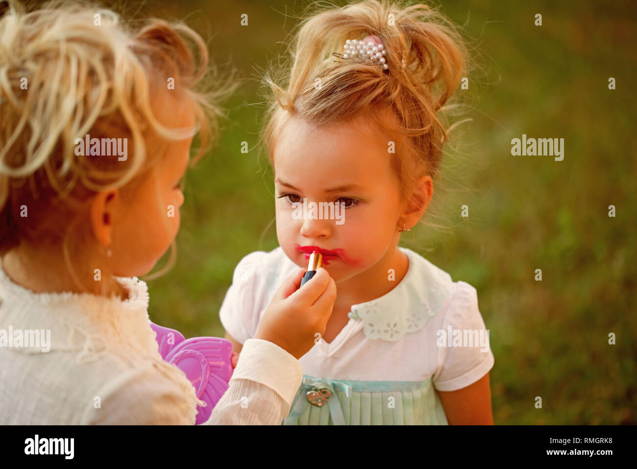 Baby apply red lipstick on lips of kid model Stock Photo Alamy