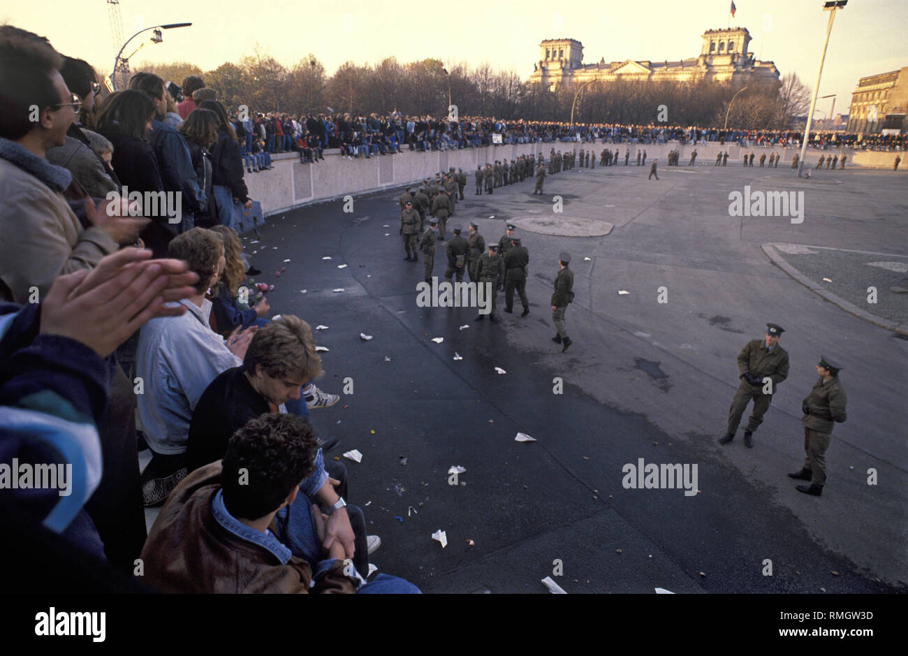 Thousands of residents of East and West Berlin celebrate the opening of the border on the Berlin Wall at the Brandenburg Gate. GDR frontier guards prevent people from entering the restricted area at the square in front of the Brandenburg Gate and Pariser Platz. Stock Photo