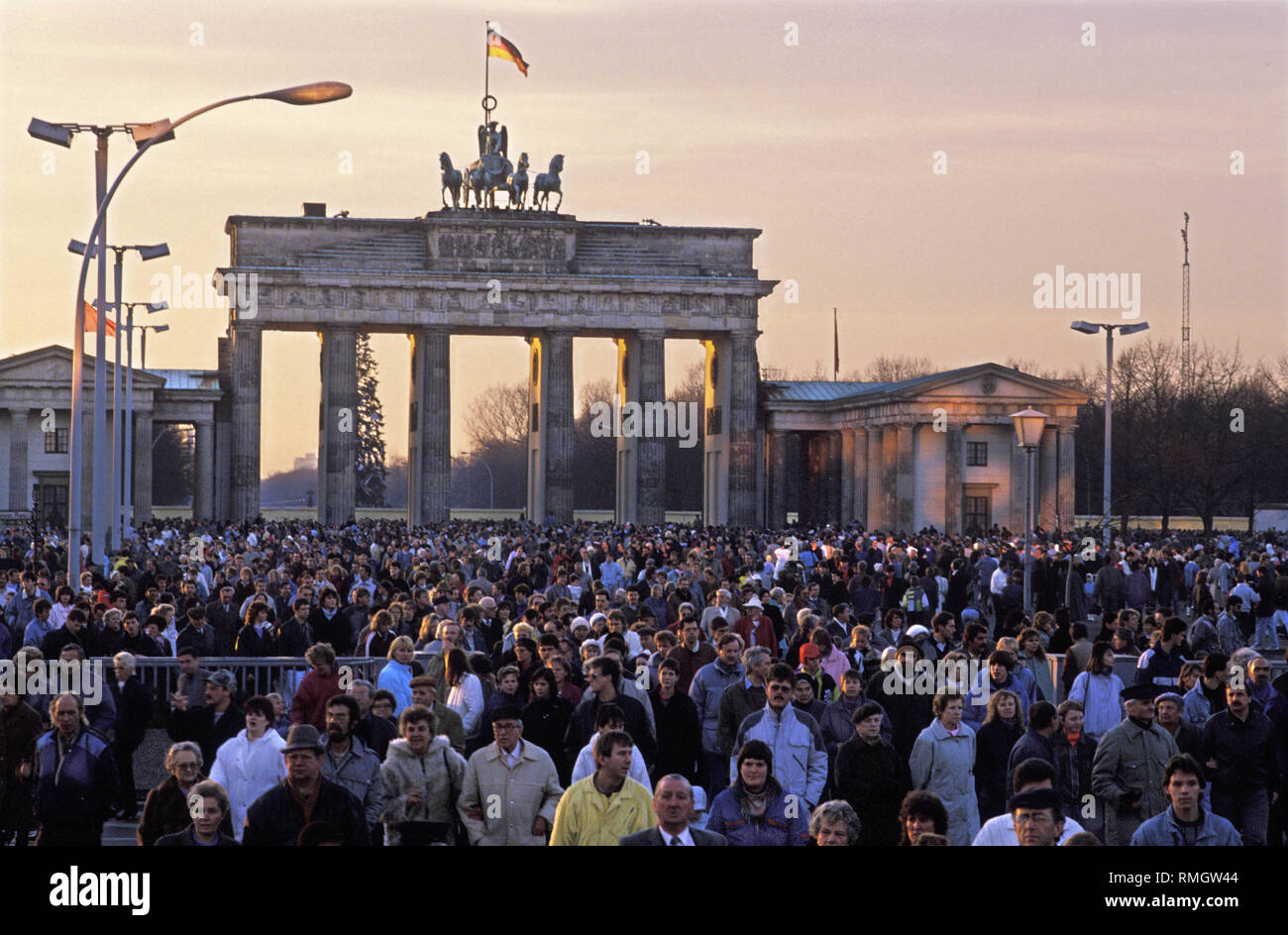 Visa-free tourist traffic for residents of West Germany becomes possible between the GDR and the FRG after long negotiations on December 24, 1989. The minimum obligatory exchange at the border was also dropped. Thousands of people from Berlin and visitors take advantage of the new regulation for a Christmas trip to the Brandenburg Gate. The Pariser Platz has become accessible to the public for the first time since the Wall was built. Stock Photo