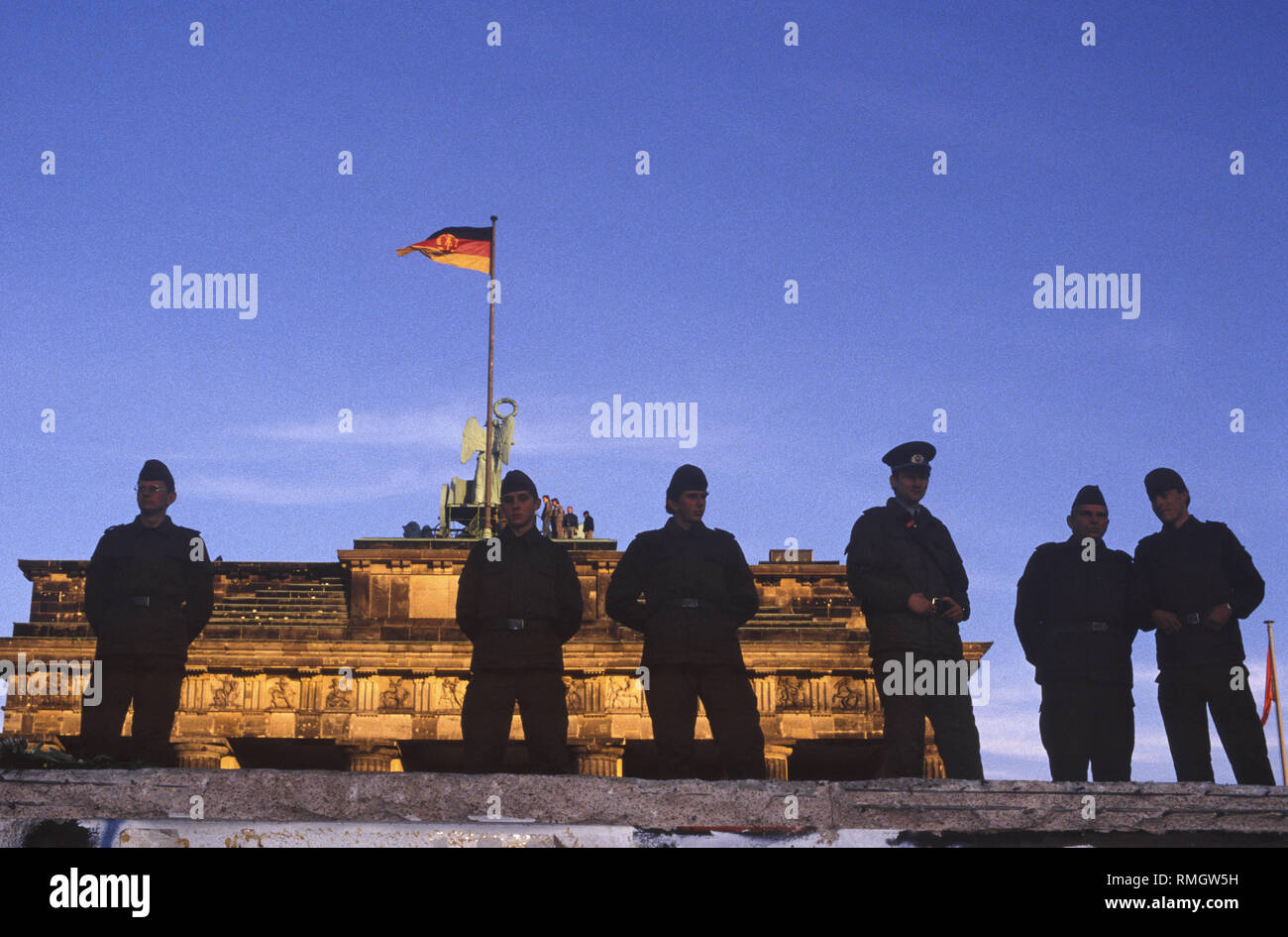 Thousands of East and West Berliners celebrate the opening of the border on the Berlin Wall at the Brandenburg Gate.  GDR frontier guards prevent people from entering the restricted area at the square in front of the Brandenburg Gate and the Pariser Platz. Stock Photo