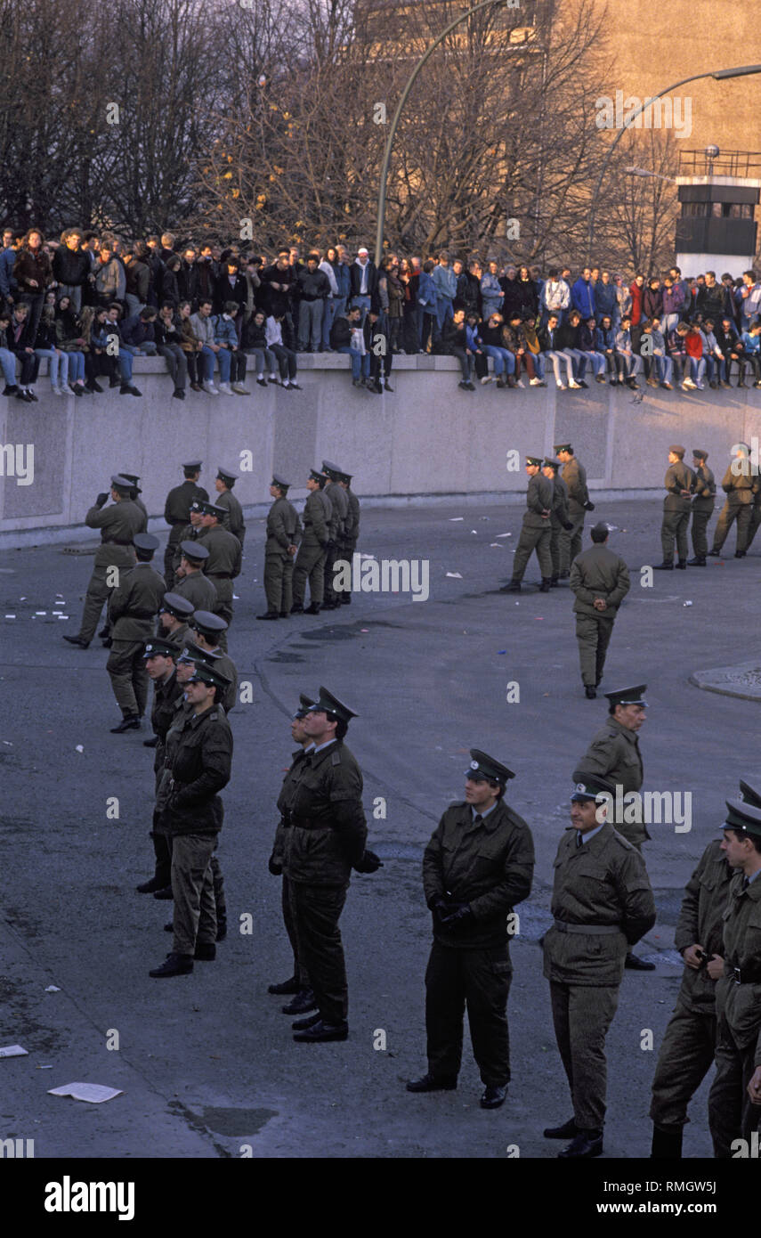 Thousands of East and West Berliners celebrate the opening of the border on the Berlin Wall at the Brandenburg Gate.  GDR frontier guards prevent people from entering the restricted area at the square in front of the Brandenburg Gate and the Pariser Platz. Stock Photo