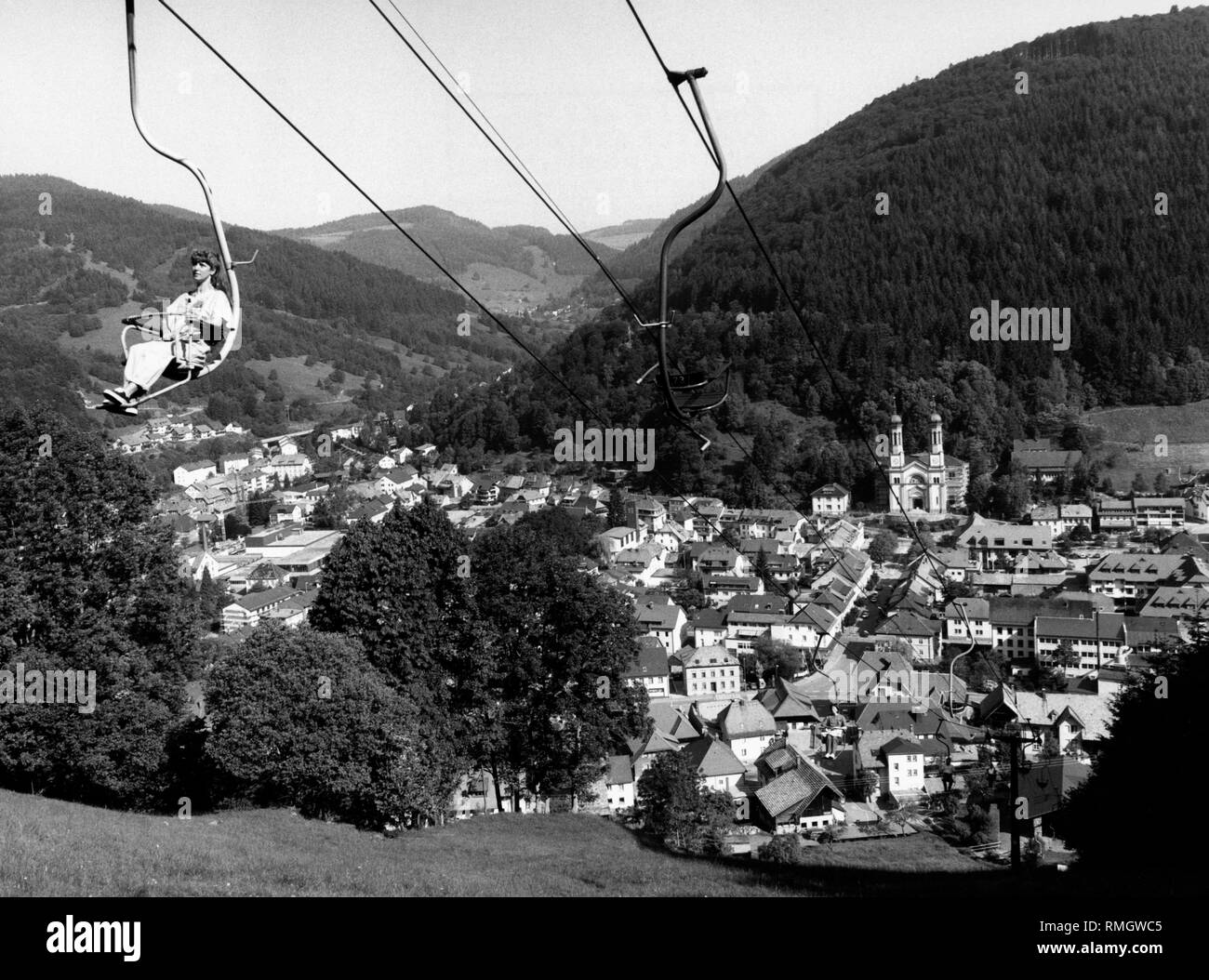 View over Todtnau in the Black Forest. In the foreground a woman, who sits in a chair lift. Undated picture. Stock Photo