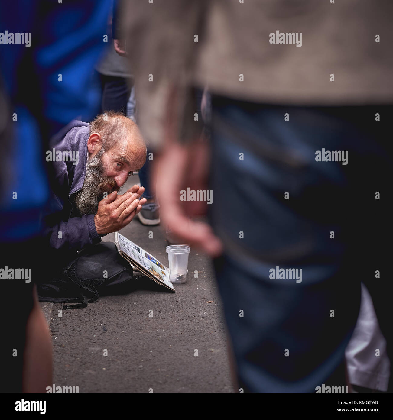 London, UK - June, 2018. An old homeless man begging for help in a crowded Borough Market. Stock Photo